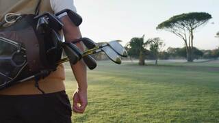 Person Carrying golf bag on golf course