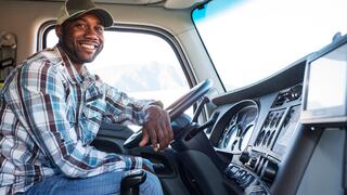 A driver inside a truck sitting and smiling