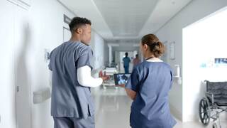 Medical People on tablet walking down hallway